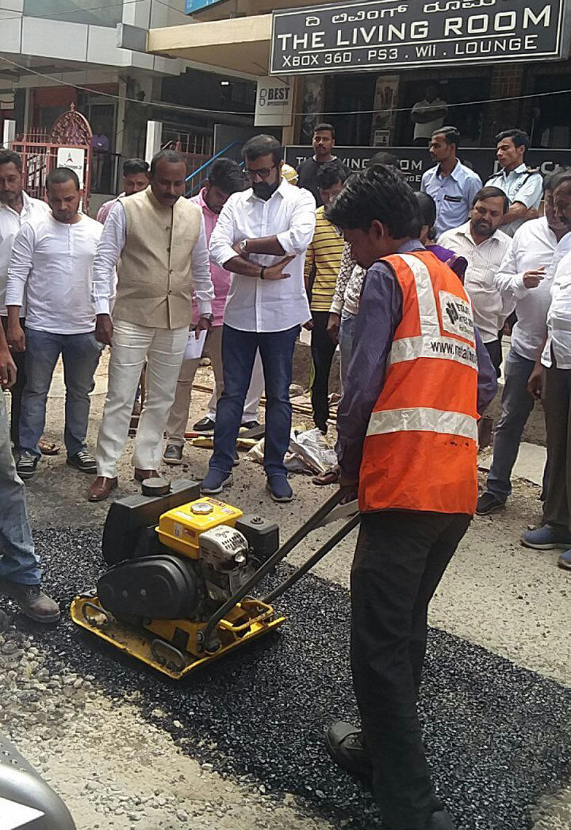 BBMP Mayor Sampath Raj and MLA N A Haris inspecting pothole filling at Residency service road in Bengaluru on Sunday.