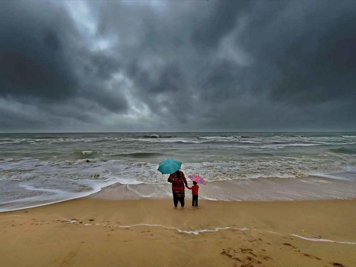 A woman standing with her son at Marina beach following heavy downpour due to the onset of Northeast monsoon in Chennai on Monday.