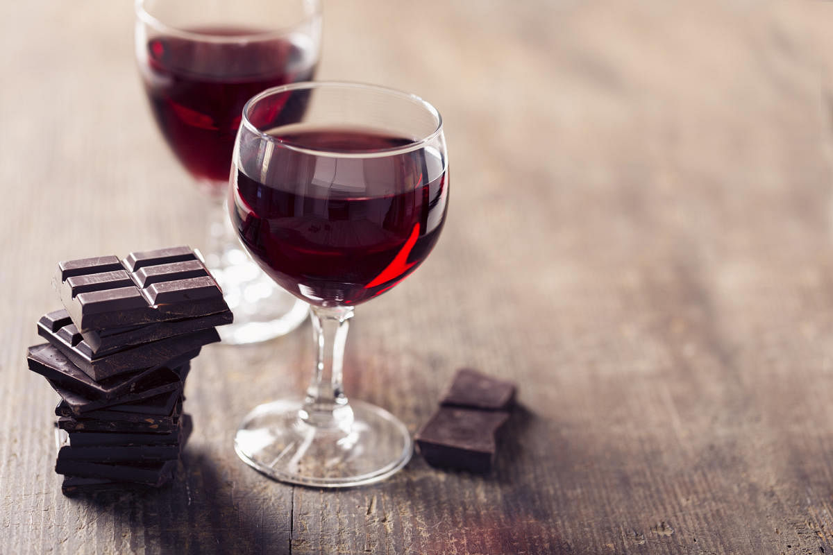 2 glaases with red wine and dark chocolate on wooden background, a wonderful combinationWine &amp; chocolates