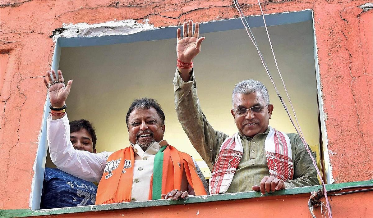 Mukul Roy (left) with West Bengal BJP president Dilip Ghosh during his first visit to the state party office after his induction into the party, in Kolkata on Monday. PTI