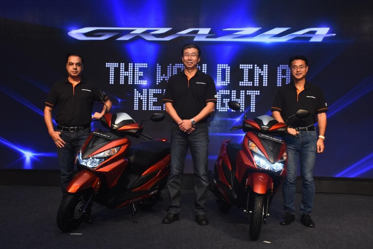 Honda Motorcycle and Scooter India President and CEO Minoru Kato (cntre) and his colleagues unveil the new urban scooter Grazia in Mumbai on Wednesday.