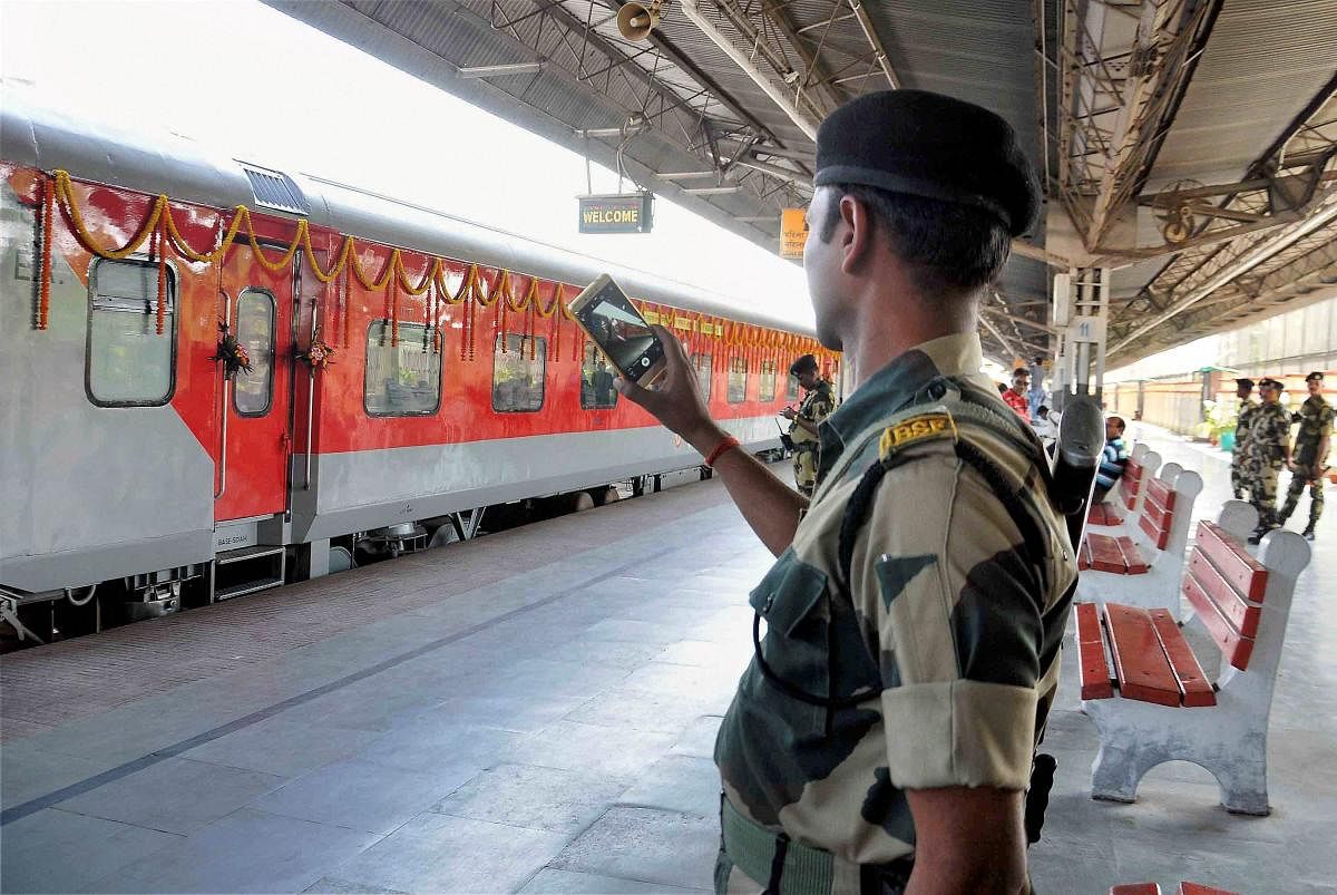 A BSF personnel takes pictures of Kolkata-Khulna(Bangladesh) Bandhan Express train with his mobile phone during its flagging off ceremony, in Kolkata on Thursday. PTI