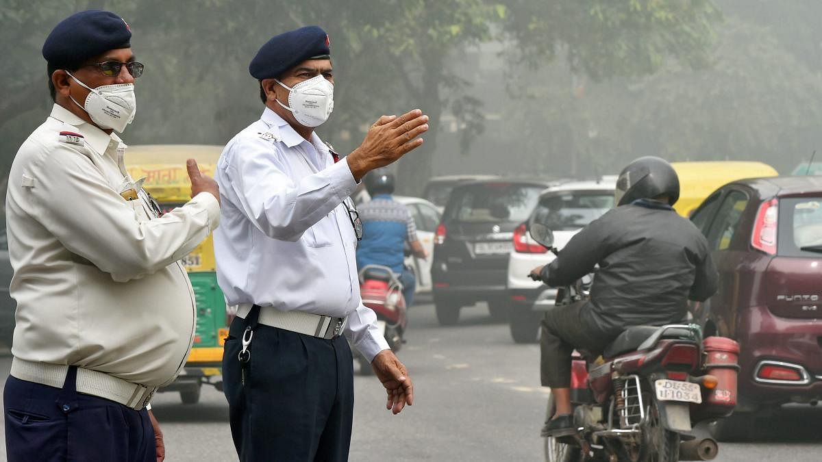 Traffic policemen wear masks to protect themselves from heavy smog and air pollution while manning the traffic, in New Delhi. PTI file photo.