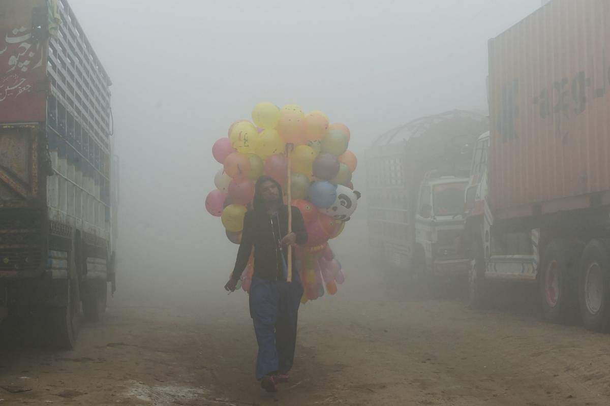 Haze of colours: A Pakistani vendor on a street amid heavy smog in Lahore. Pakistan suffers from some of the worst air pollution in the world, thanks to its giant population navigating poorly maintained vehicles, unchecked industrial emissions and seasonal crop burning. AFP