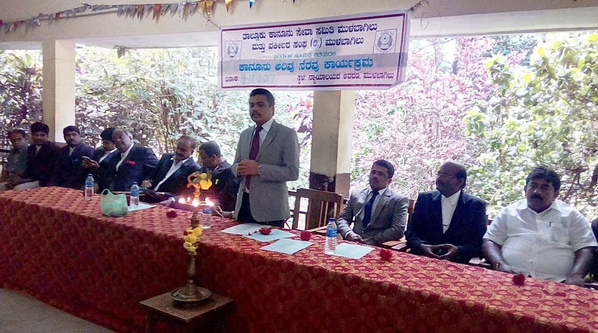 Principal Civil Judge A A Shafeer speaks at the National Legal Services Day programme in Mulbagal. DH photo