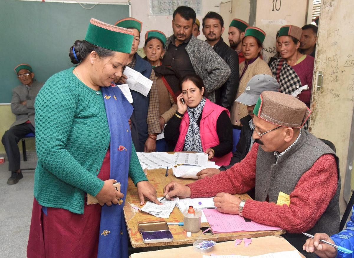 Kinnaur: A polling staff applying indelible ink on the finger of a woman voter at a polling both during the state's Assembly elections, in Khwangi village dist. Kinnaur, Himachal Pradesh on Thursday. PTI Photo/PIB (PTI11_9_2017_000194B)