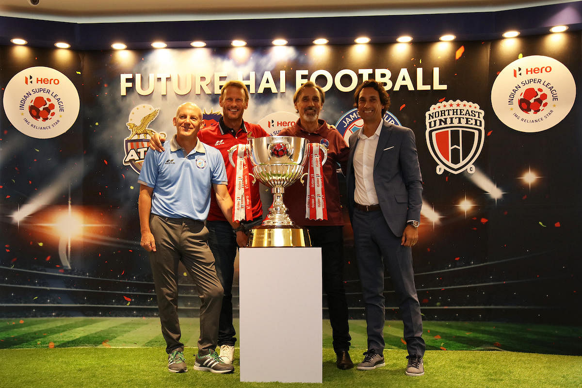 Head coaches of the Indian Super league sides (From left) Steve Coppell (Jamshedpur FC), Teddy Sheringham (ATK), Miguel Portugal (Delhi Dynamos) and Joad de Deus (North East United FC) pose with the trophy at the ISL Media Day in Kolkata on Sunday. ISL Media