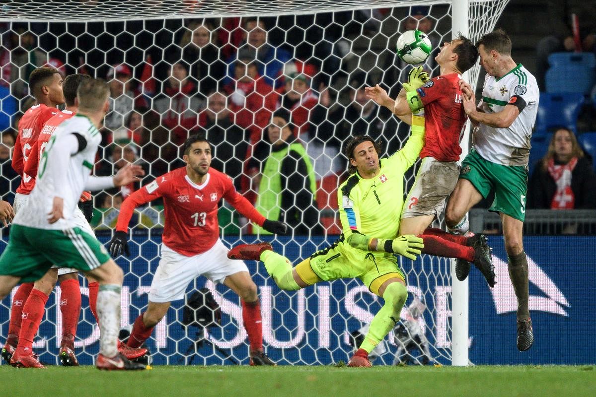Switzerland's goalkeeper Yann Sommer (centre) tries to block a header from Jonny Evans (right) of Northern Ireland during their World Cup qualifying play-off tie on Sunday. AFP