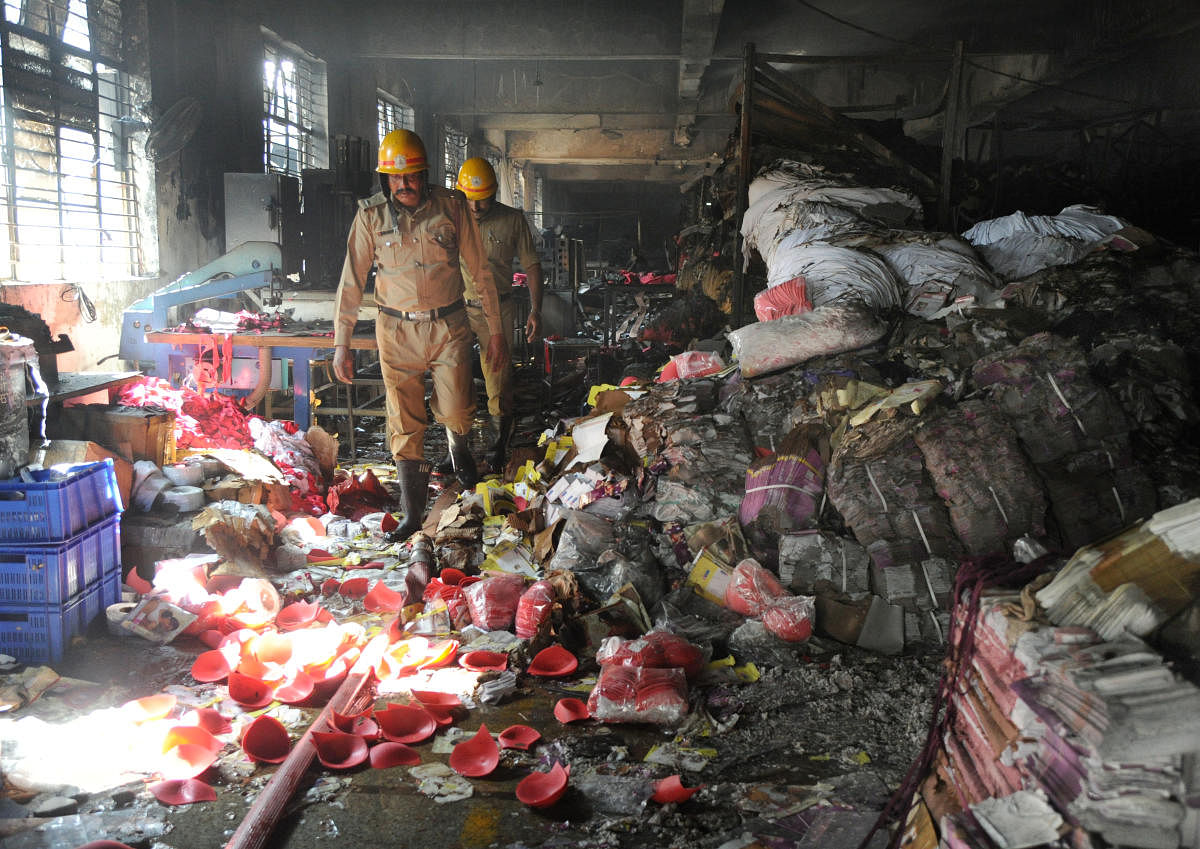 Firemen looking at the burnt garment metarials at the Lovable Lingerie limited garments factory at Konanakunte cross on Kanakapura road in Bengaluru on Monday morning. Photo Srikanta Sharma R.