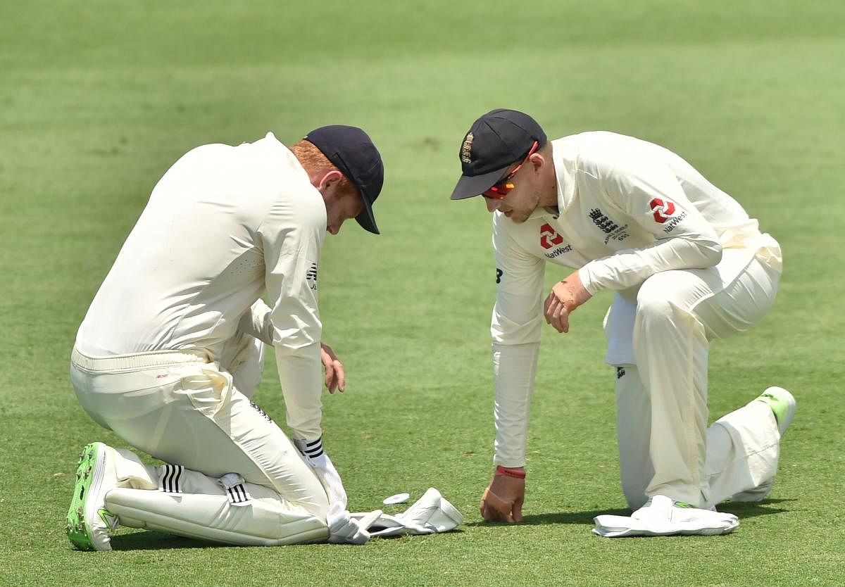 England's captain Joe Root (right) checks on Jonny Bairstow after he injured his hand against Cricket Australia XI at the Tony Ireland Stadium in Townsville on Wednesday.