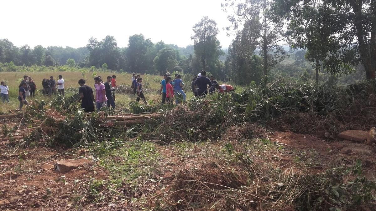 Students clear and level the land at Bommarbettu village in Udupi.