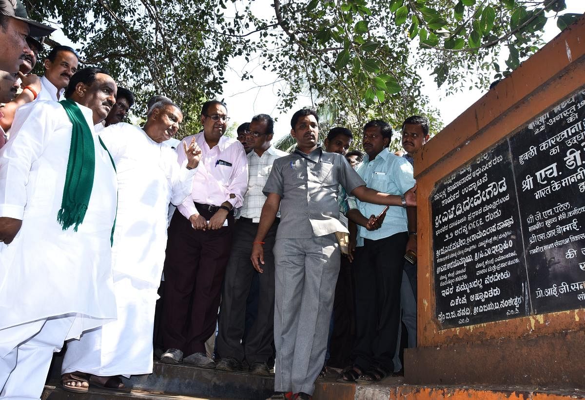 JD(S) supremo H D Deve Gowda takes a look at the foundation stone plaque for the renovation work he had launched as prime minister in 1996, on the railway workshop premises in Hubballi on Thursday. MLA N H Konaraddi and others look on. dh photo
