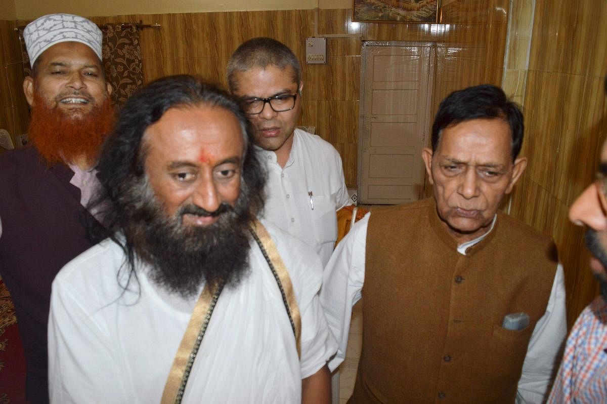 Spiritual leader Sri Sri Ravi Shankar with Haji Mahboob, a petitioner in the title suit of the Mandir-Masjid dispute, after a meeting at his residence in Faizabad on Thursday. PTI File Photo