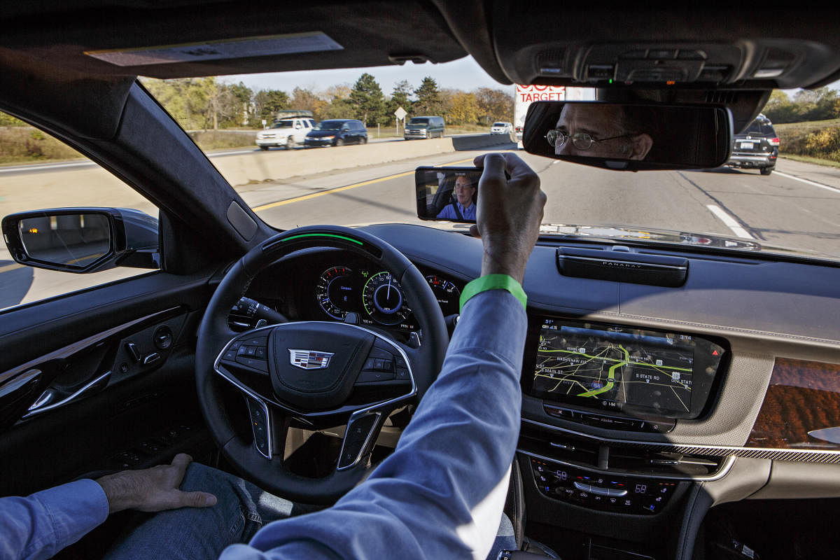 Neal Boudette, with no hands on the wheel, takes a selfie with his mobile phone while on Interstate 94 in a semi-autonomous 2018 Cadillac CT6 luxury sedan, in Ann Arbor, Mich., Nov. 8, 2017. The car's Super Cruise system uses a radar sensor, cameras, GPS positioning and a highly precise digital map, to handle all of the braking, accelerating and steering, if you desire, when driving on divided, limited-access highways such as interstates. (Sean Proctor/The New York Times)