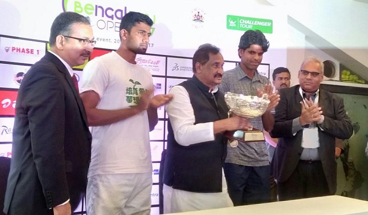 Bengaluru Development Minister K J George unveils the trophy of Bangalore ATP Challenger at KSLTA stadium at Cubbon Park on Saturday. The draw for the tournament was also held on the occasion. Promising tennis players Vishnuvardhan and Suraj Prabodh are also seen.