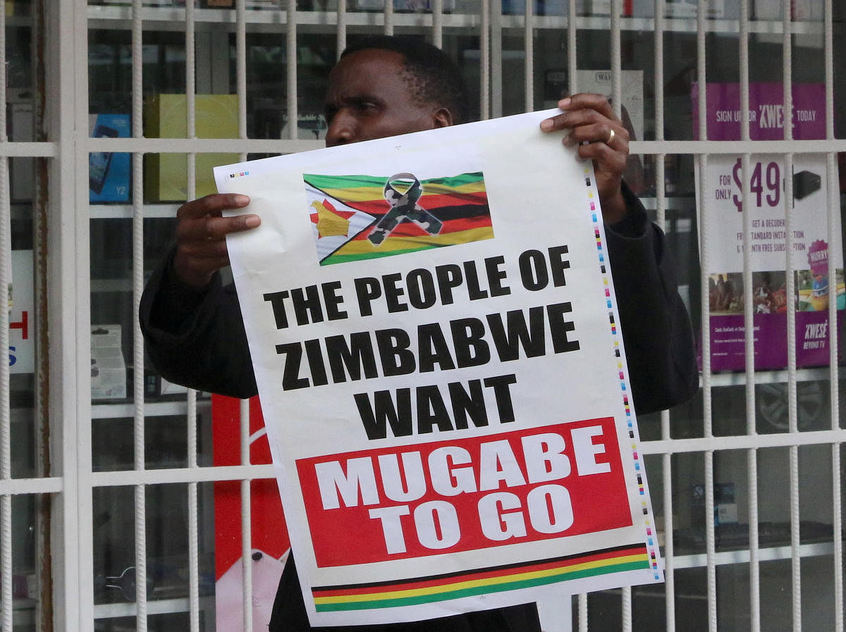 A man carries a poster calling for Zimbabwe President Robert Mugabe to step down in Harare, Zimbabwe, on Saturday. REUTERS