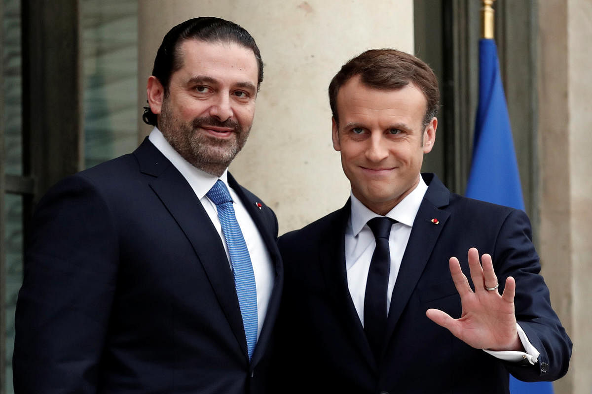 French President Emmanuel Macron and Saad al-Hariri gestures as he welcomes the latter to the Elysee Palace in Paris, France, on Saturday. REUTERS