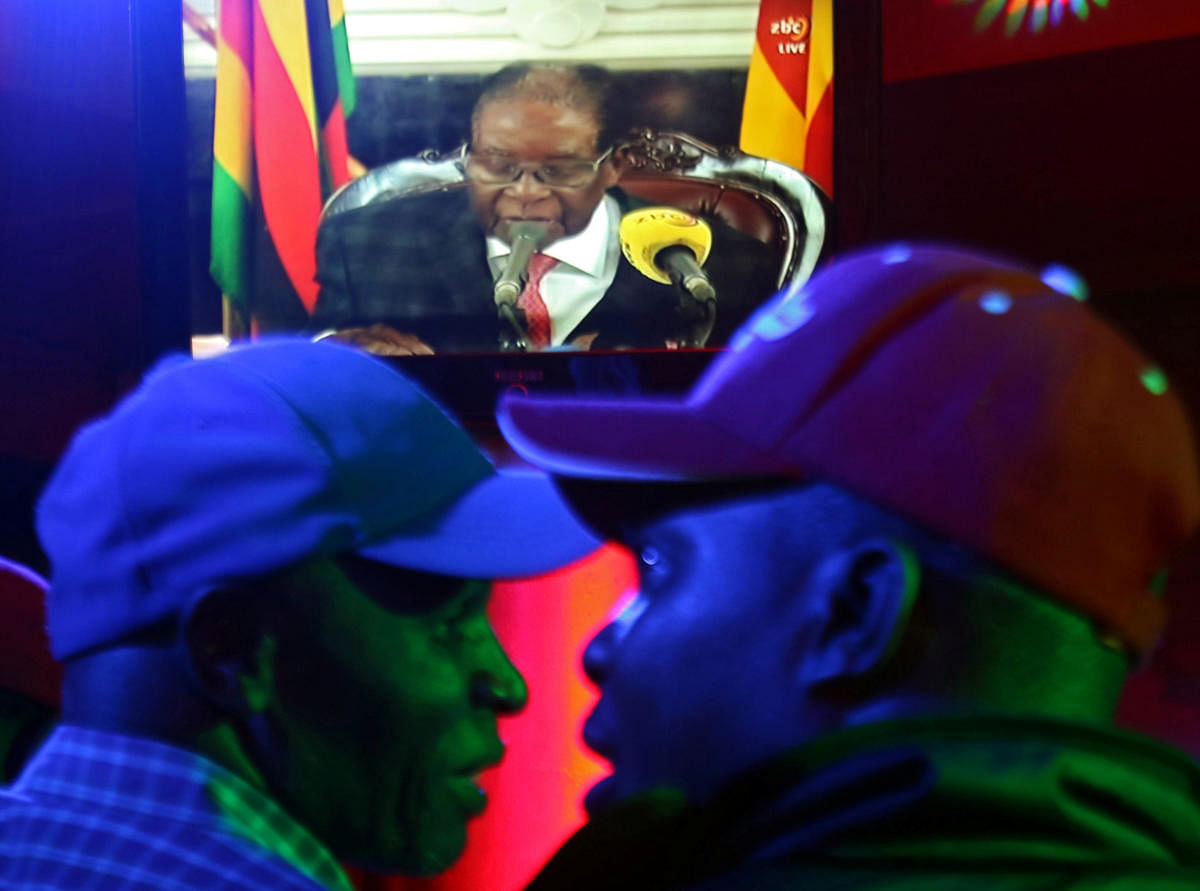 People watch as Zimbabwean President Robert Mugabe addresses the nation on television, at a bar in Harare. Reuters Photo