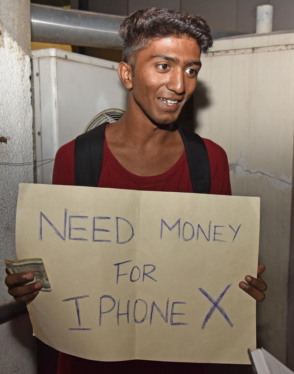Mohammed Zaid (student) standing for playing a prank to collect cash for Phone X in MG Road, Bengaluru on Monday. Photo by S K Dinesh