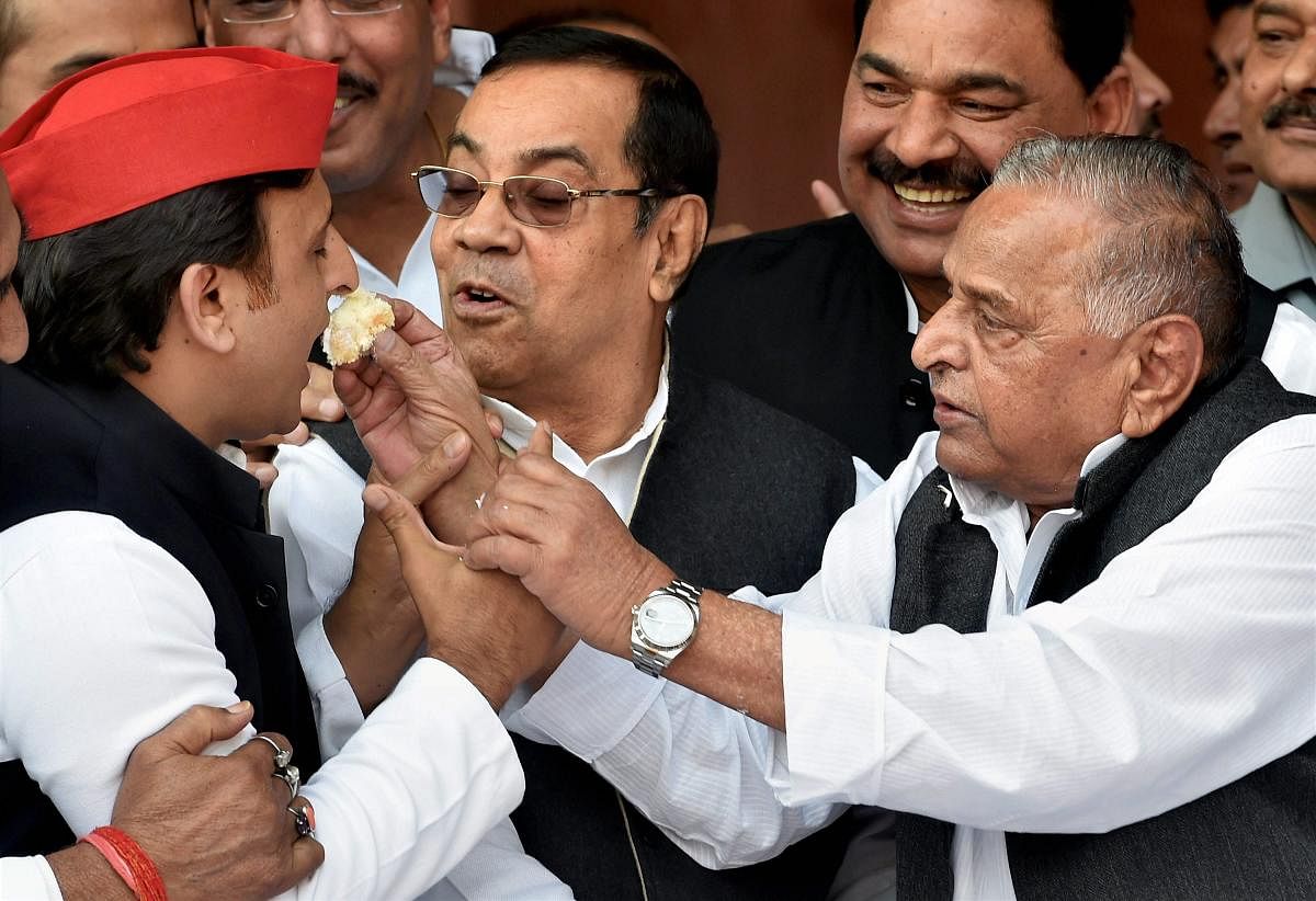 Samajwadi Party founder Mulayam Singh Yadav offers cake to his son and party president Akhilesh Yadav during his 79th birthday celebrations in Lucknow on Wednesday. PTI