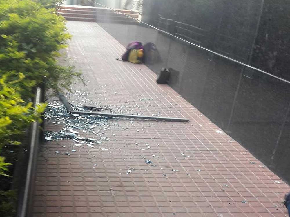 The glass pane of a window on the fourth floor suddenly came crashing down, hitting a parapet wall and then falling on the two students who were below. Image courtesy: Facebook