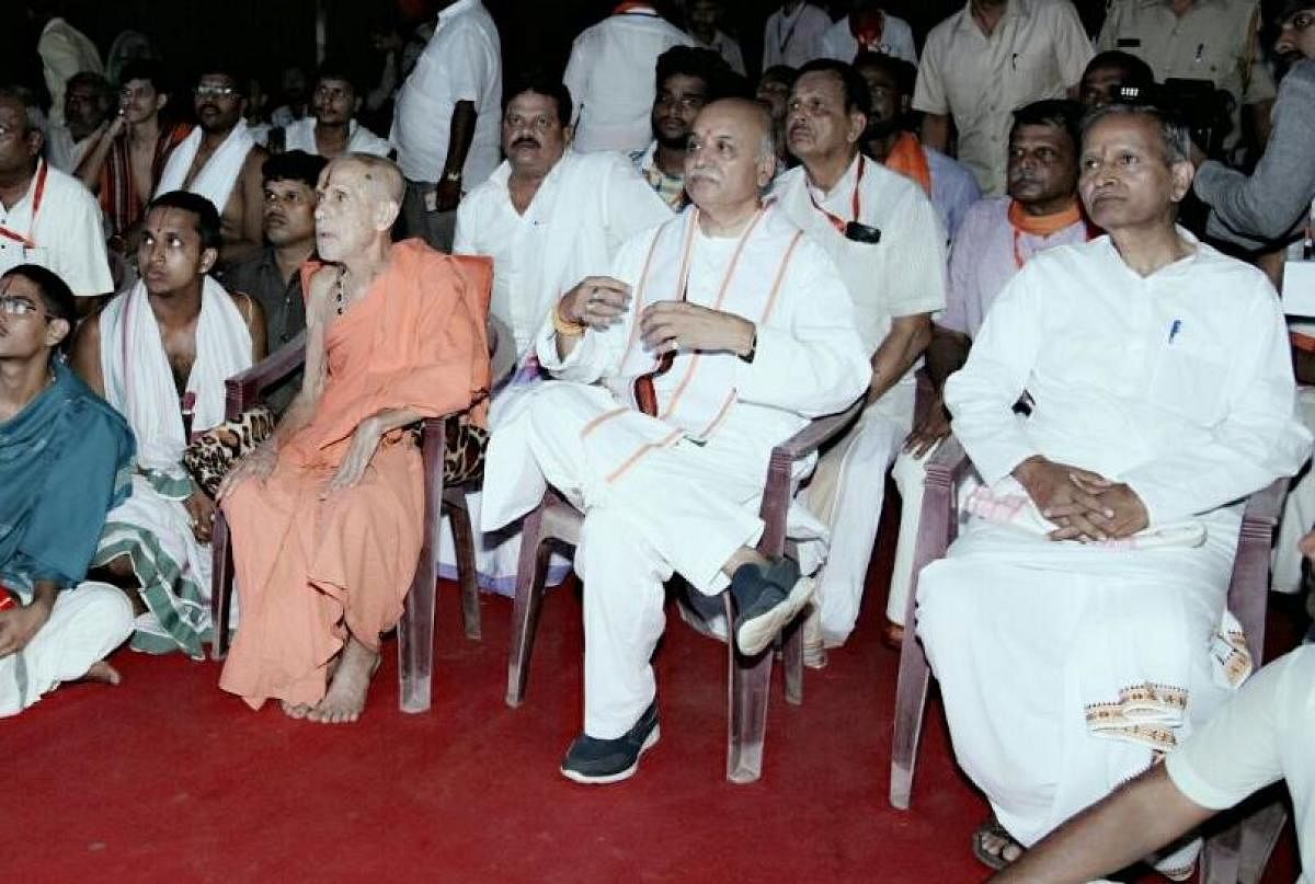 A photo of VHP leader Pravin Togadia sitting cross-legged next to Pejawar seer Vishwesha Thirtha Swamy during a programme in Udupi on Friday has gone viral on social media. DH PHOTO