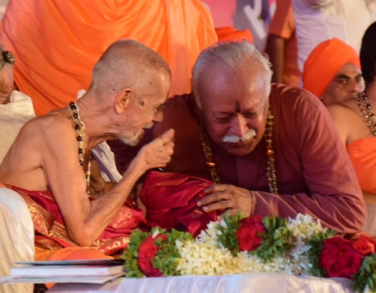 Pejawar seer Vishwesha Thirtha Swami in conversation with RSS chief Mohan Bhagwat during the inaugural day of Dharma Sansad in Udupi on Friday. DH PHOTO