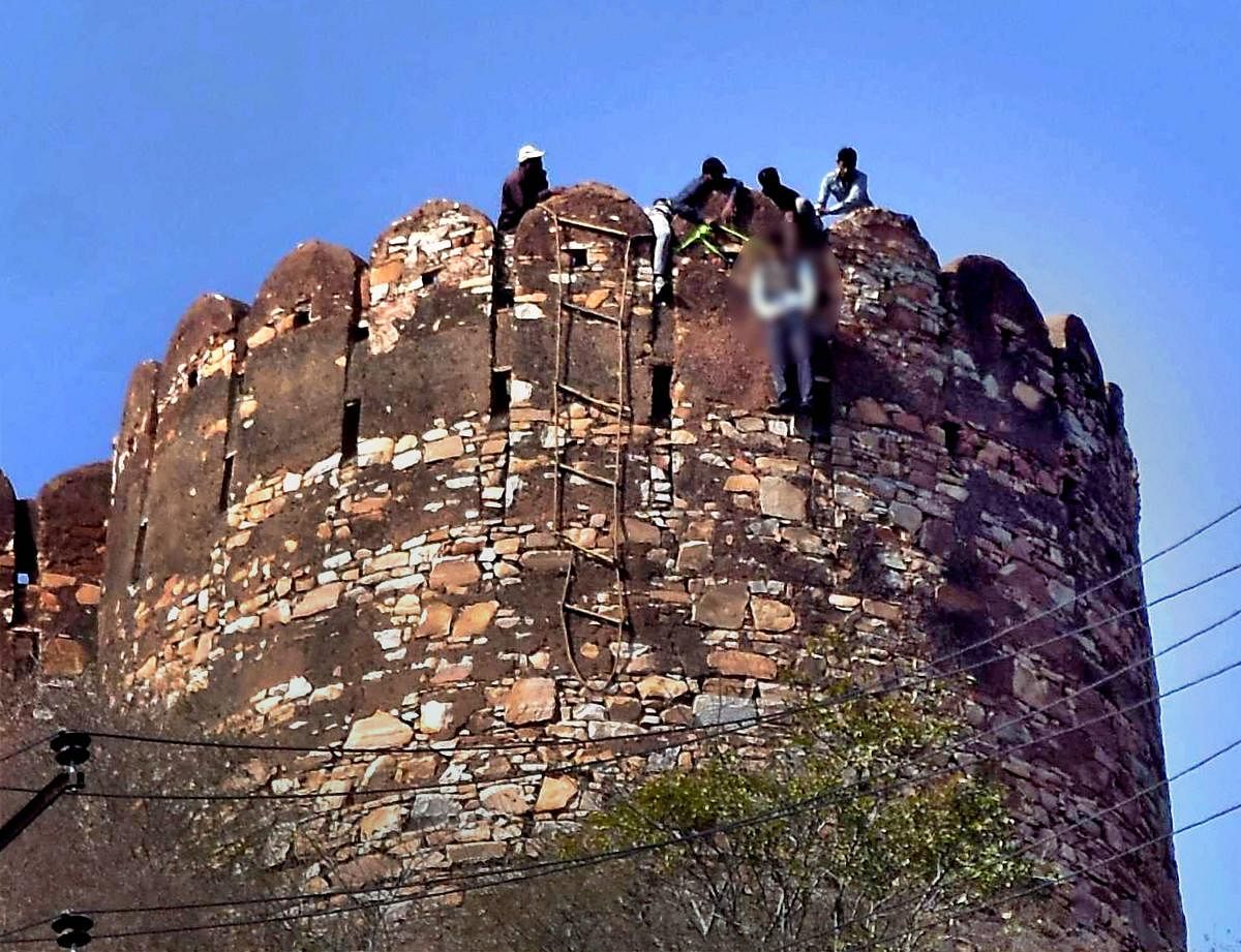 Rescue workers remove the body of a youth found hanging from Nahargarh Fort near Jaipur on Friday, with anti-Padmavati slogans written nearby. PTI
