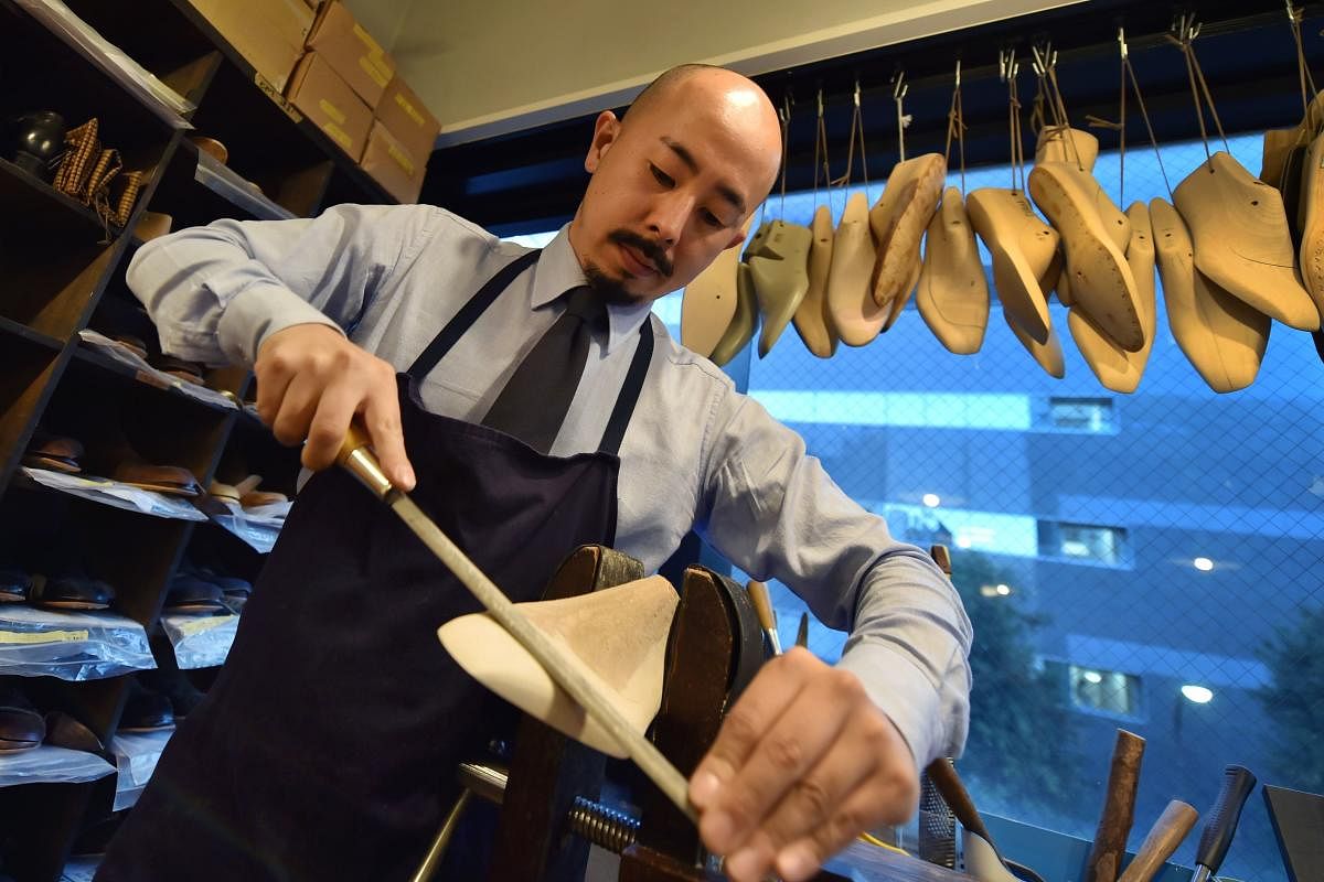 This photo taken on November 7, 2017 shows Japanese master shoemaker Yohei Fukuda working in his workshop in Tokyo. When Yohei Fukuda left for England more than a decade ago to learn his trade as a master leather shoemaker, he could hardly have imagined that his native Japan would one day become a leader in this traditionally European art. / AFP PHOTO / Kazuhiro NOGI