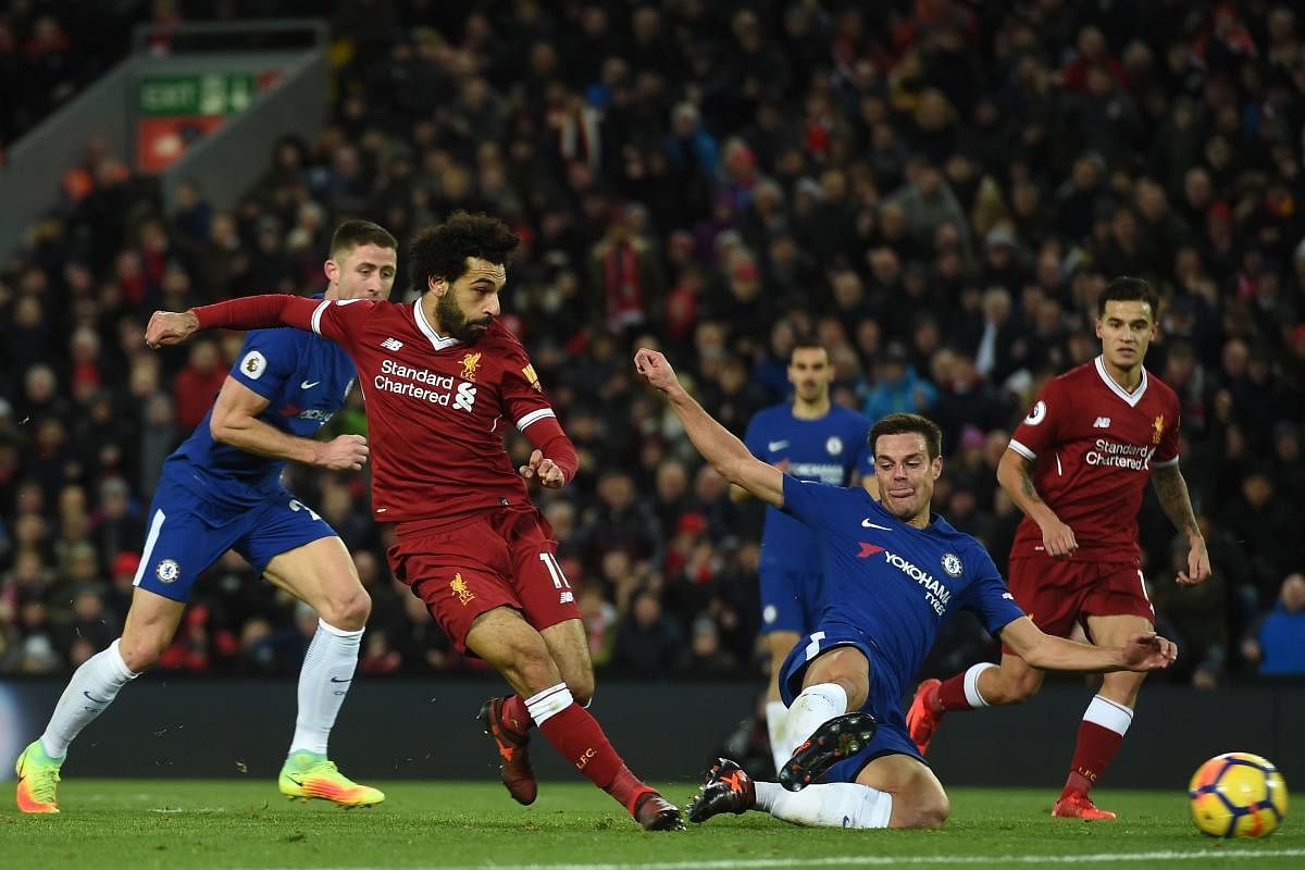 Liverpool's Egyptian midfielder Mohamed Salah (2nd L) shoots past the challenge of Chelsea's Spanish defender Cesar Azpilicueta (2nd R) to score the opening goal of the English Premier League football match between Liverpool and Chelsea at Anfield in Liverpool, north west England on November 25, 2017. / AFP PHOTO / Paul ELLIS / RESTRICTED TO EDITORIAL USE. No use with unauthorized audio, video, data, fixture lists, club/league logos or 'live' services. Online in-match use limited to 75 images, no video emulation. No use in betting, games or single club/league/player publications. /