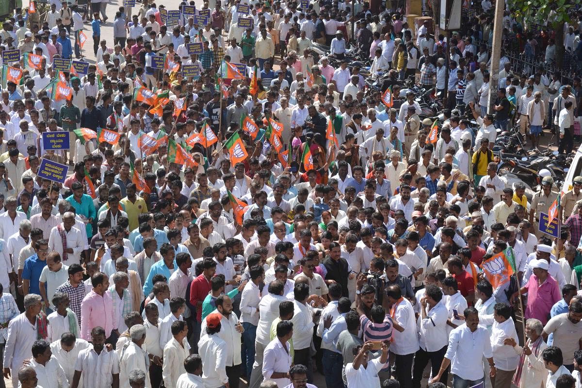 BJP workers taking out rally in Dharwad on Monday, demanding resignation of Mines and Geology Minister Vinay Kulkarni. DH Photo.