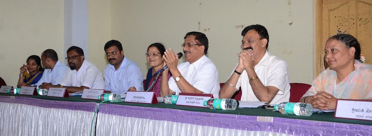 MLA K G Bopaiah speaks at tri-monthly KDP meeting of Taluk Panchayat in Madikeri on Tuesday.
