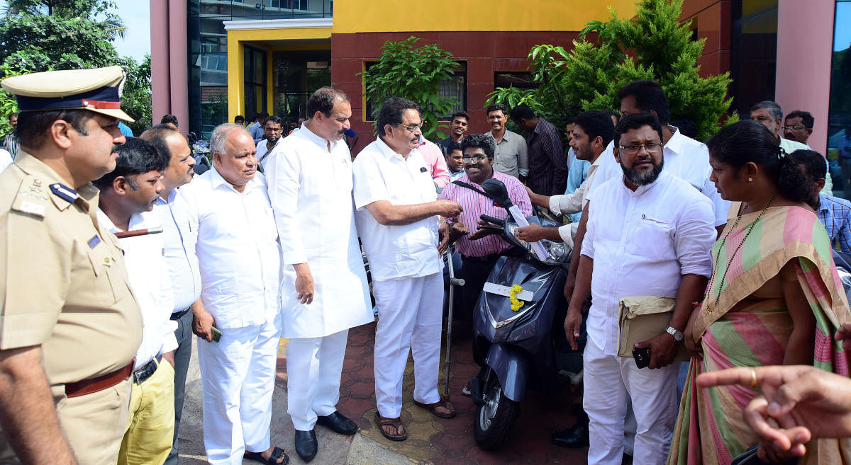 District-in-Charge Minister B Ramanath Rai hands over the Vehicle key to Disable person at ZP Premises in Mangaluru on Thursday. DH Photo/ Govindraj Javali