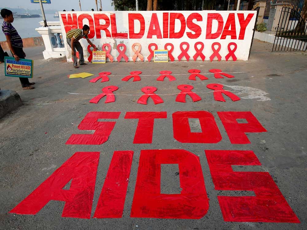 A man places a placard as he prepares a message during an HIV/AIDS awareness campaign on the eve of World AIDS Day in Kolkata. Reuters Photo