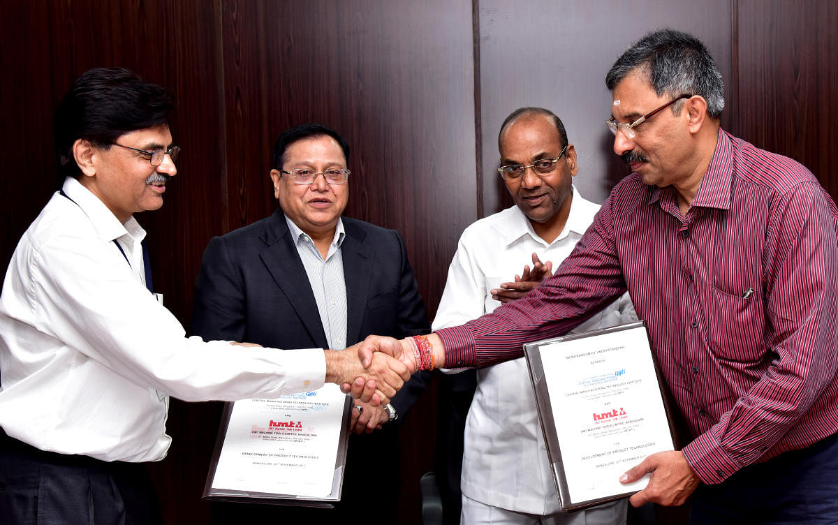 Satish Kumar, Director, CMTI (Left) and Giresh Kumar, CMD, HMT (Right) are exchange the signing of MoU, during the Union Minister Ananth G Geete(Second from Right), visit to Central Manufacturing Technology Institute (CMTI), in Bengaluru on Thursday. Dr V K Saraswath, Governing Council President, CMTI is also seen. Photo/ B H Shivakumar