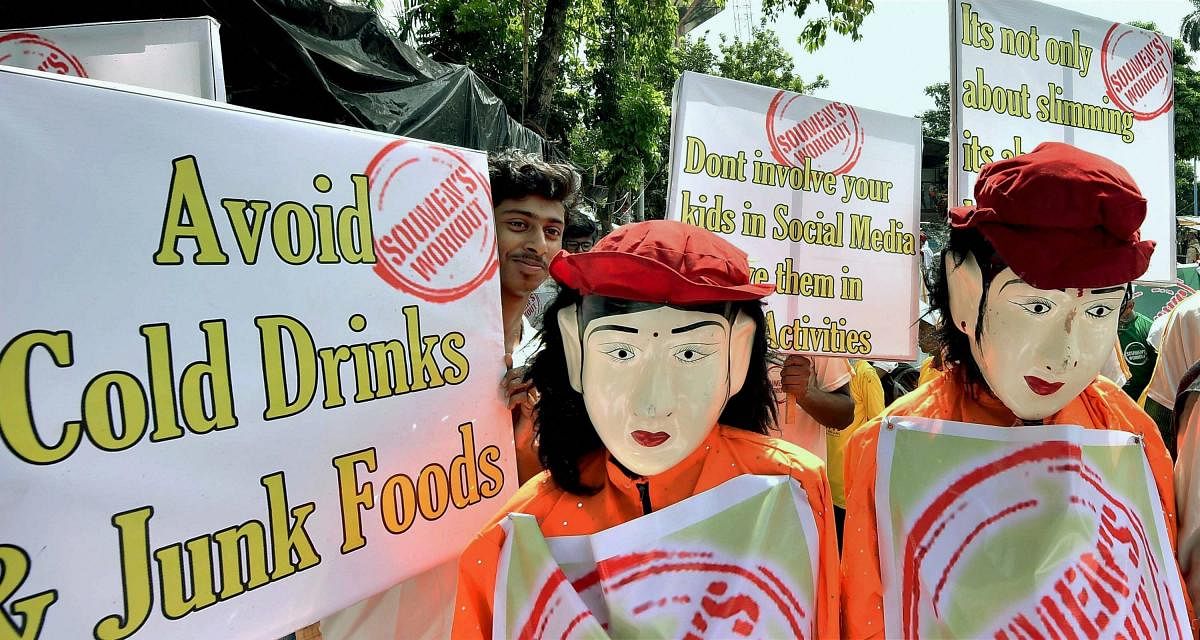 Activists, dressed up as mascots, participate in an awareness campaign against fast foods in Kolkata while observing 'World No Obesity Day' on Wednesday. PTI Photo