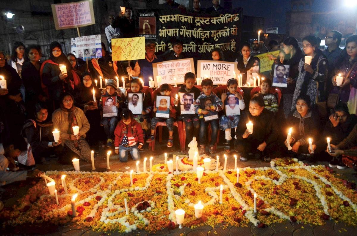 Members of Sambhavana Trust Clinic, which provide medical assistance to gas affected along with Children of survivor of gas victims during a candle light vigil to pay tributes to the people killed in gas tragedy, on 33rd anniversary of gas disaster in Bhopal on Saturday. PTI Photo