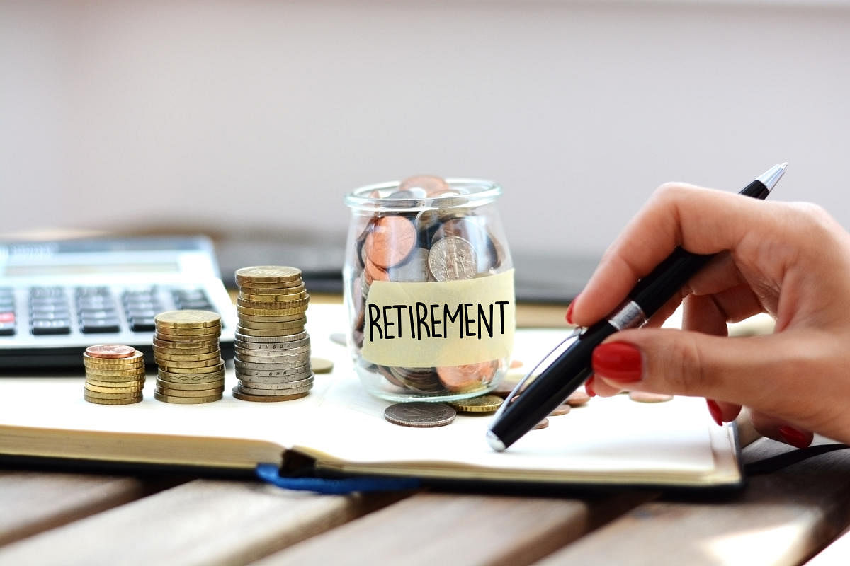 Concept of retirement planning with woman putting coins in glass jar for pensionPension