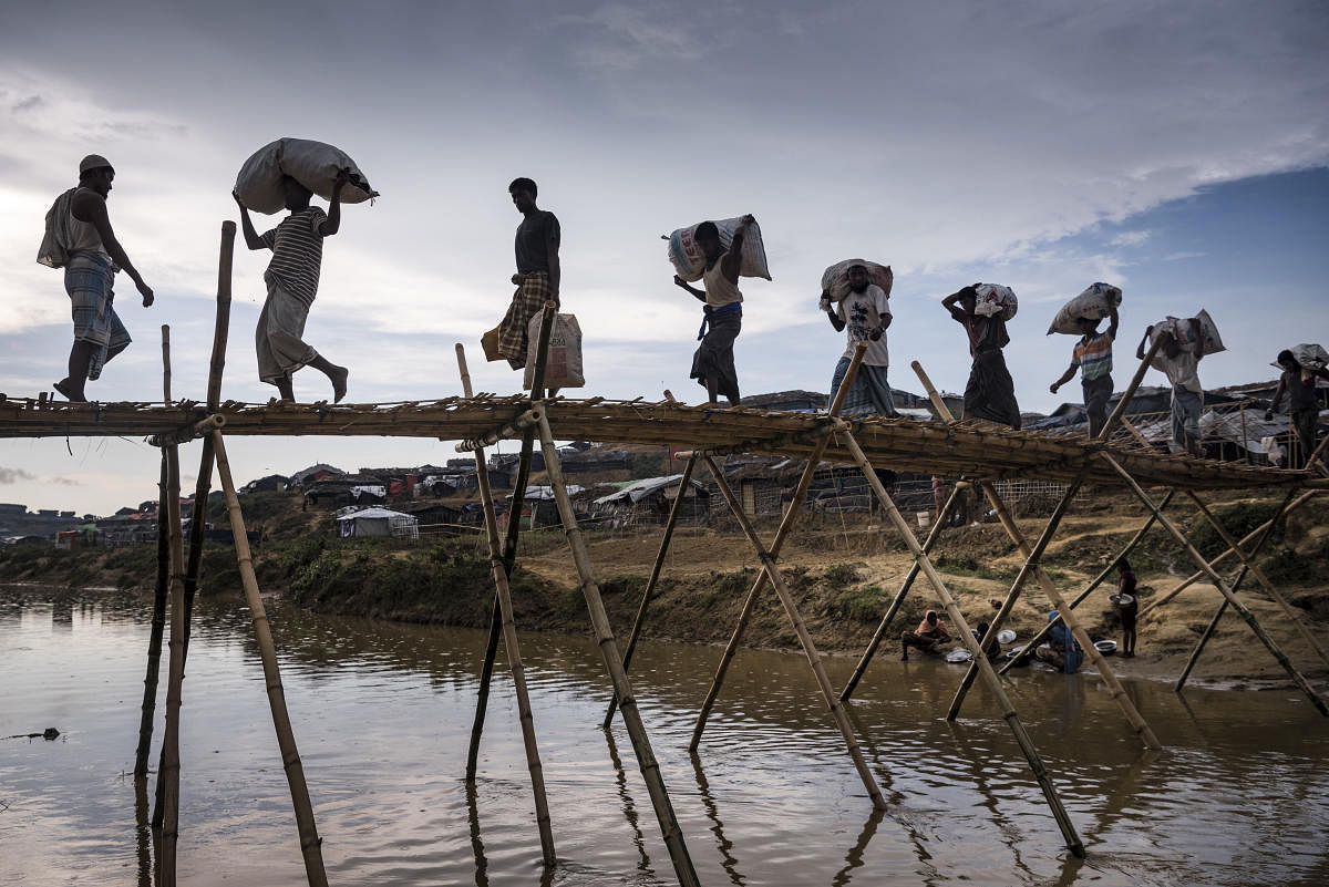 Rohingya cross a makeshift bridge in the Kutupalong refugee camp outside Cox's Bazar, Bangladesh, Oct. 3, 2017. Human rights watchdogs warn that much of the evidence of the Rohingya's history in Myanmar is in danger of being eradicated by a military campaign the U.S. has declared to be ethnic cleansing. (Sergey Ponomarev/The New York Times)