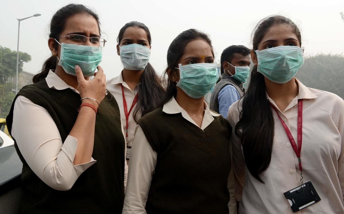 Girls protect themselves from pollution with face masks in New Delhi. AFP File