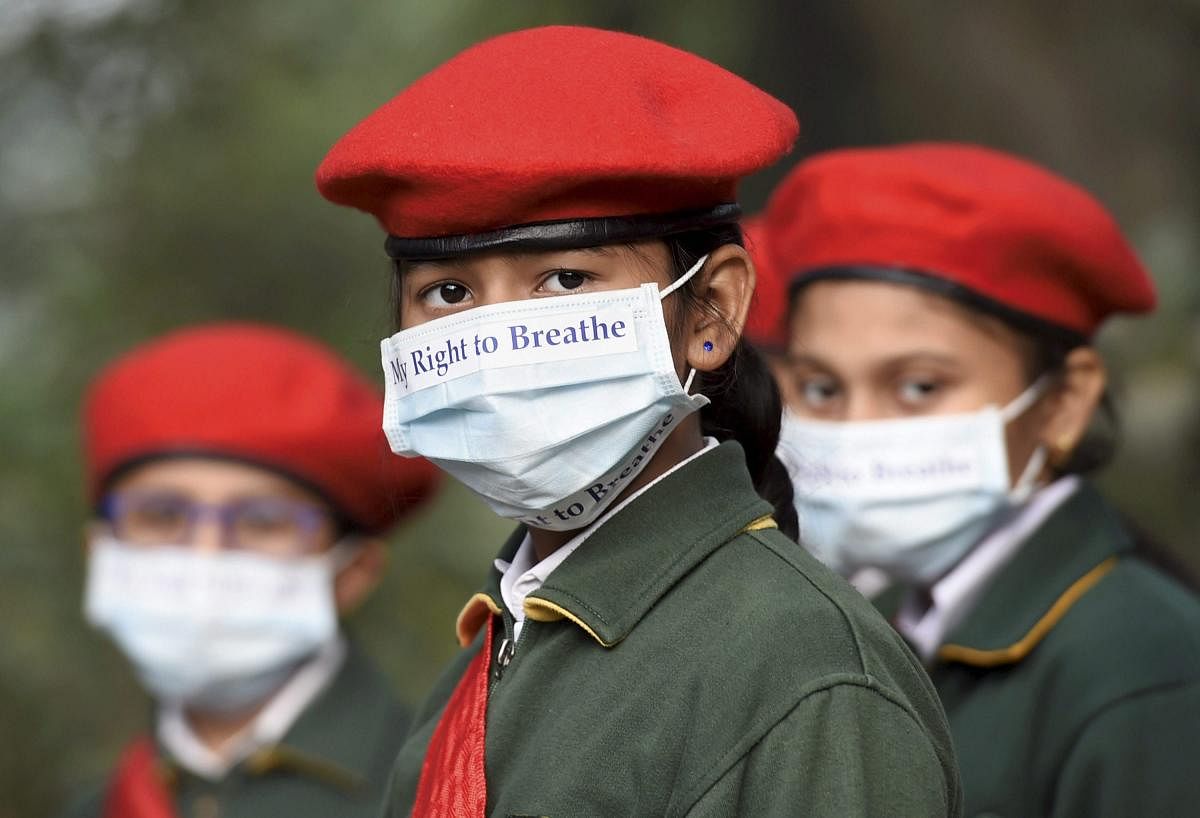 School children, wearing masks, take part in an awareness march on the alarming levels of air pollution in the city, in New Delhi. PTI Photo