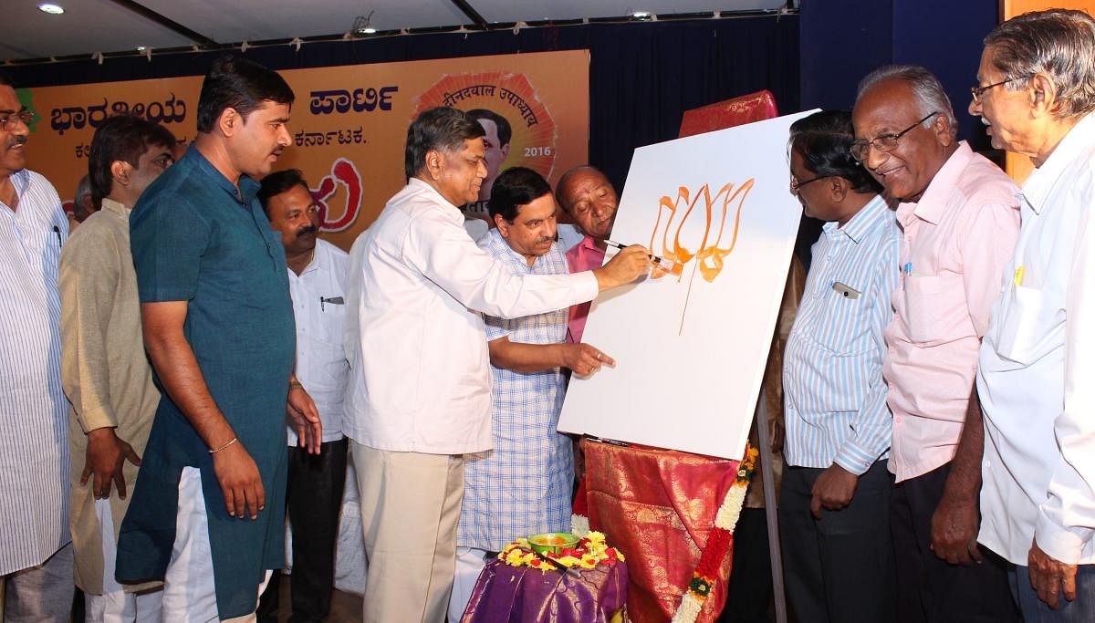 Leader of Opposition in Legislative Assembly Jagadish Shettar draws the image of BJP symbol lotus, to mark the inauguration of 'Antyodaya' art camp in Hubballi on Friday.