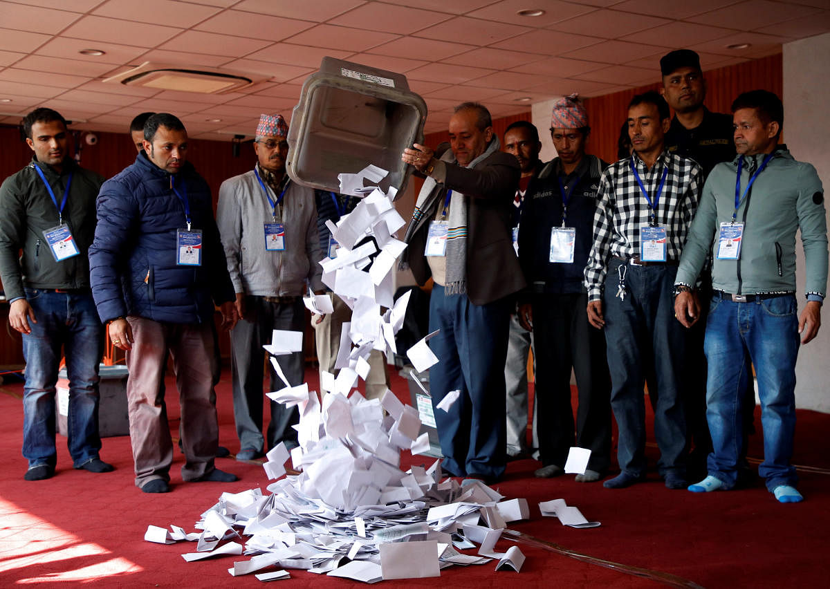 An official from the election commission pours the ballot papers from the box, as officials start counting the votes, a day after the parliamentary and provincial elections in Kathmandu, Nepal December 8, 2017. REUTERS