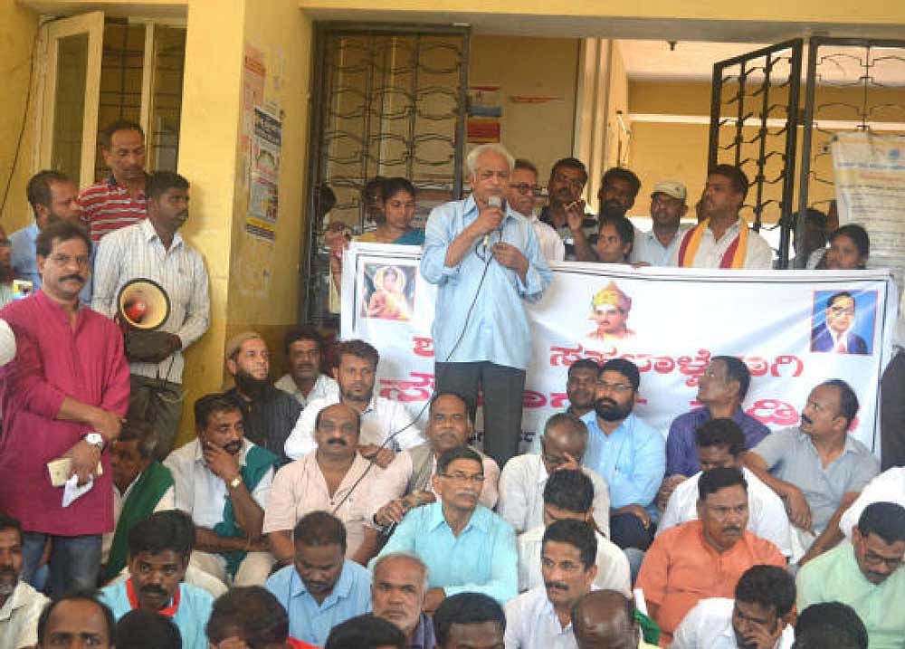 Writer K S Bhagwan addresses the participants of peace march organised in Hunsur town, on Monday.