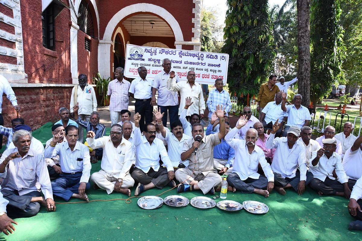 HDMC Retired Employees' Welfare Committee members stage protest in front of the HDMC commissioner's office in Hubballi on Monday.