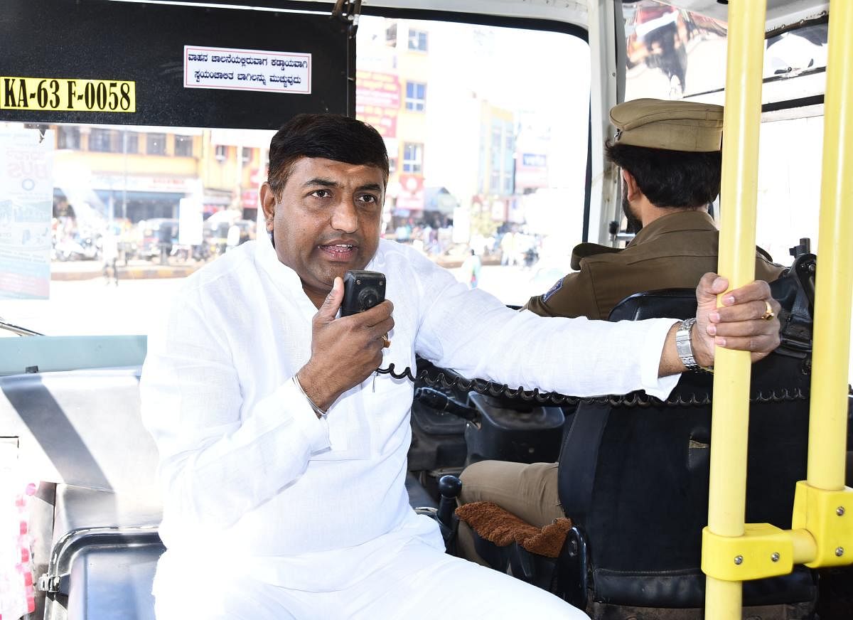 NWKRTC Chairman Sadanand Danganavar addresses media persons on a moving bus in Hubballi on Monday.