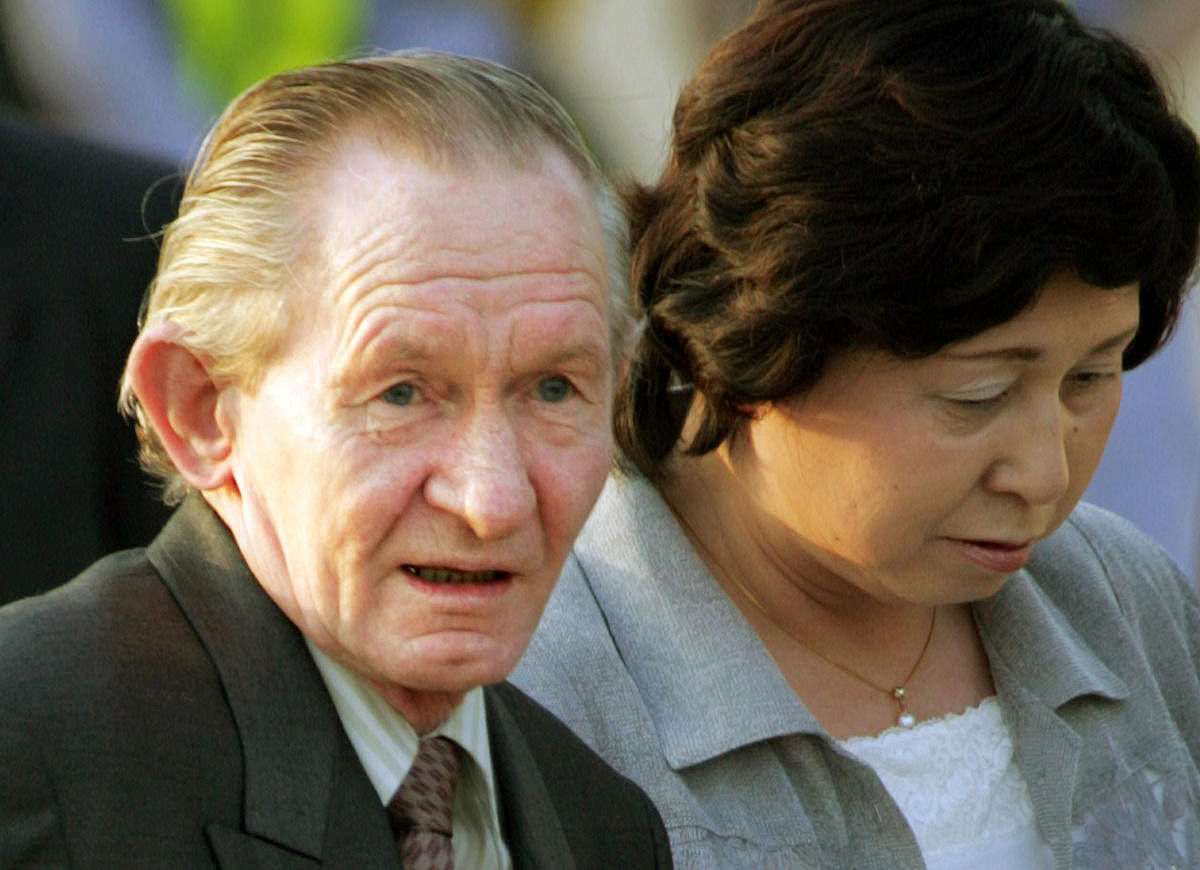 Former US army sergeant Charles Robert Jenkins is escorted by his Japanese wife Hitomi Soga as they arrive at Tokyo's Haneda airport on July 18, 2004 after being reunited in Jakarta.