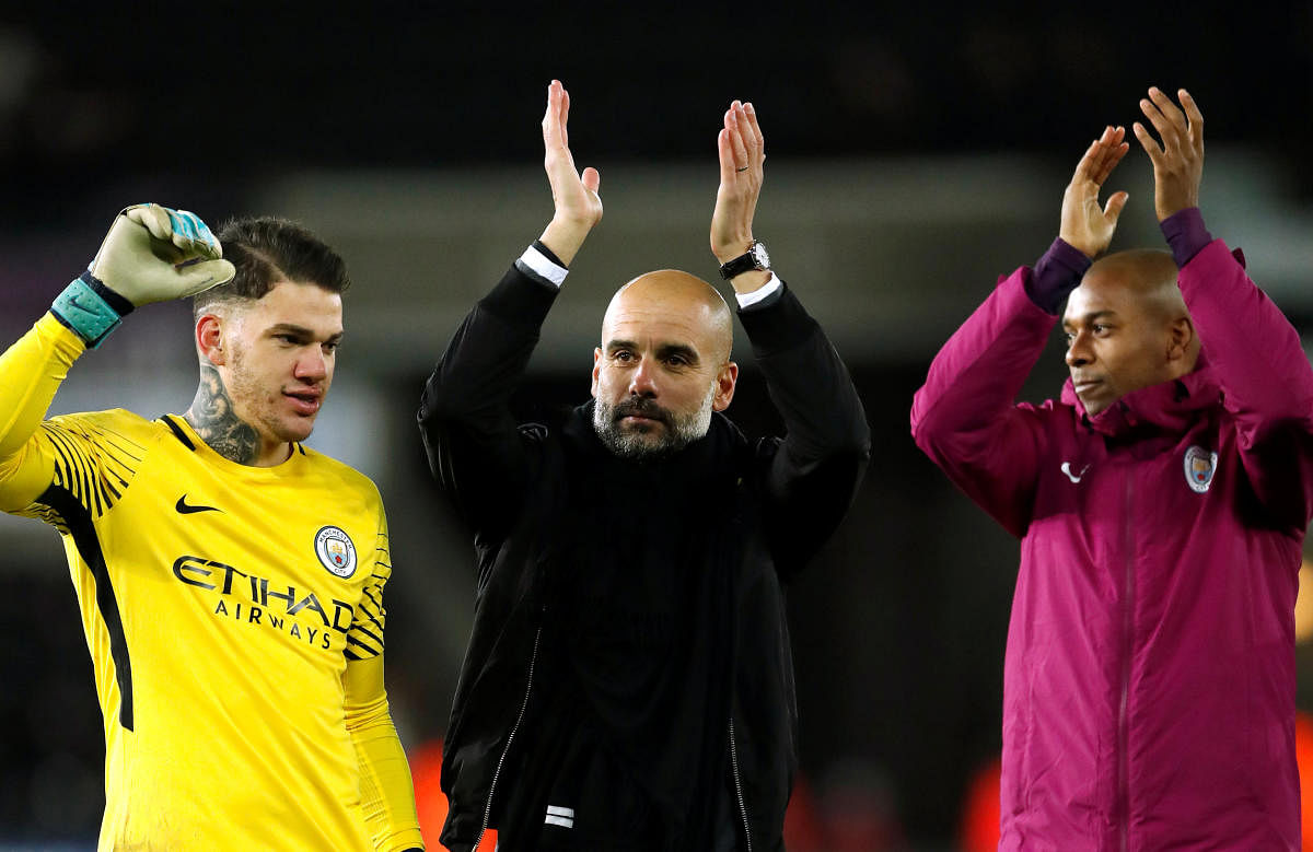 Manchester City manager Pep Guardiola (centre) applaud after their win over Swansea on Wednesday. Reuters
