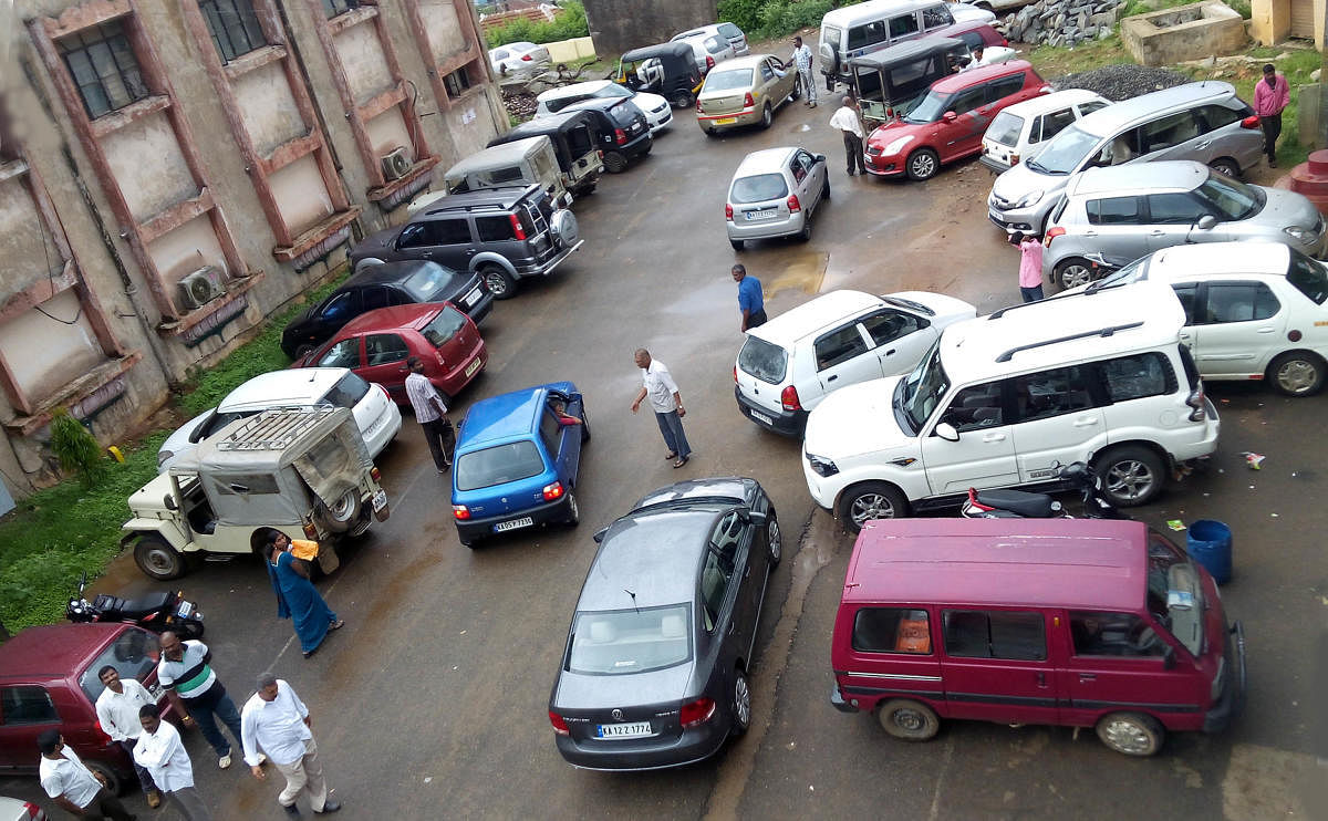 Vehicles parked in a haphazard fashion in front of Taluk Panchayat office in Somwarpet.