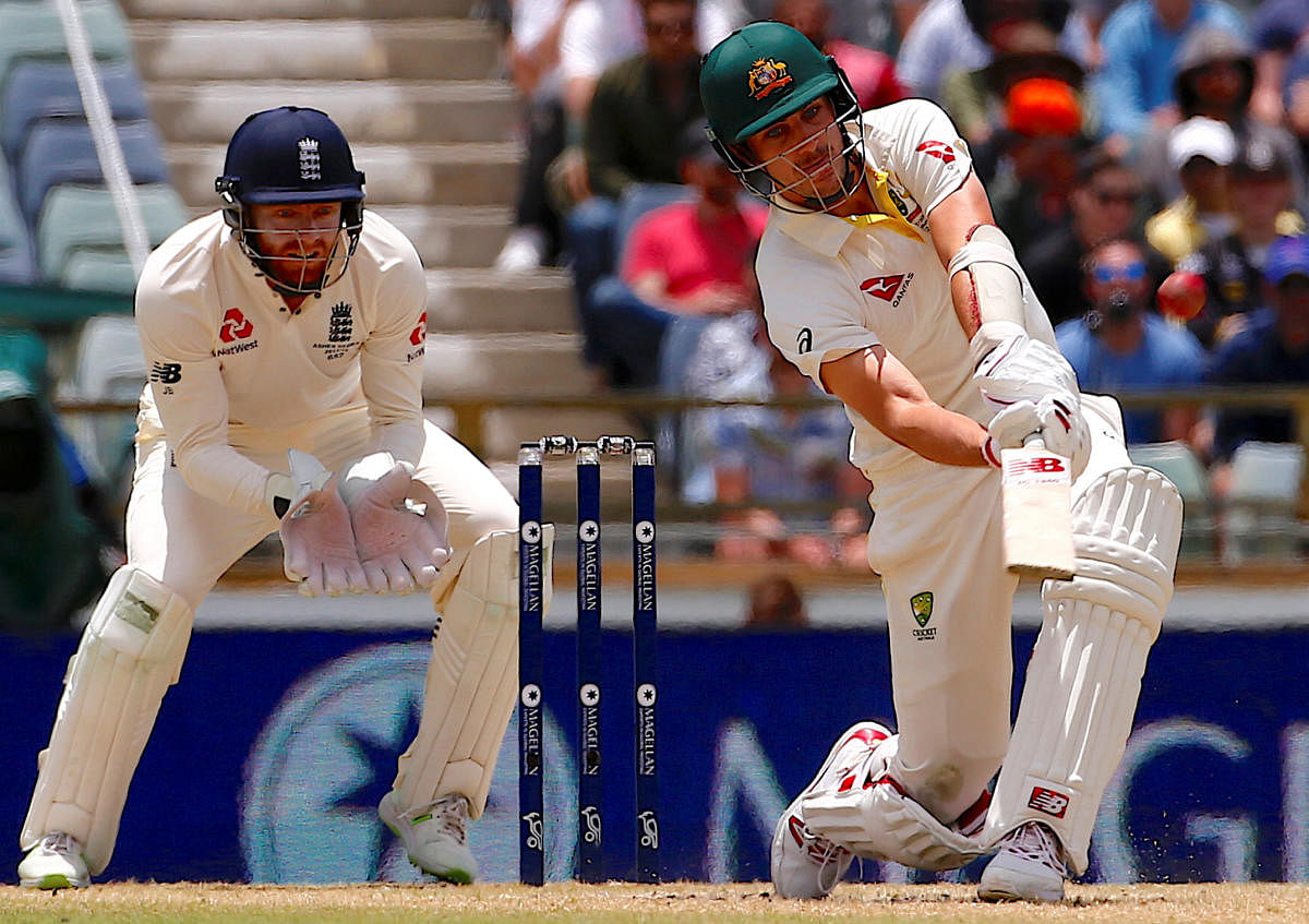 England's wicketkeeper Jonny Bairstow watches Australia's Pat Cummins hit a six during the fourth day of the third Ashes cricket test match. Reuters